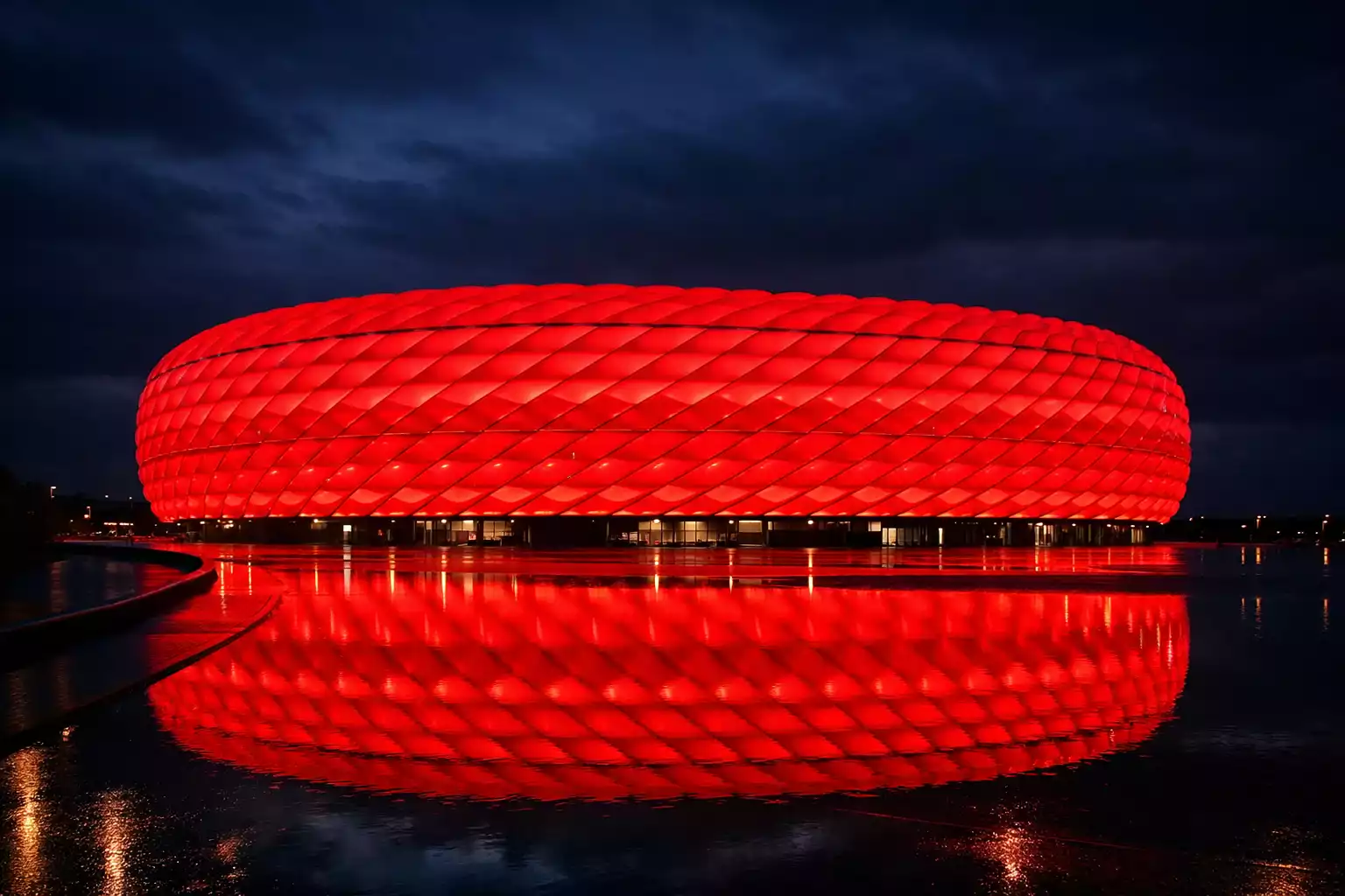 Die Allianz Arena in München bei Nacht mit roter Beleuchtung